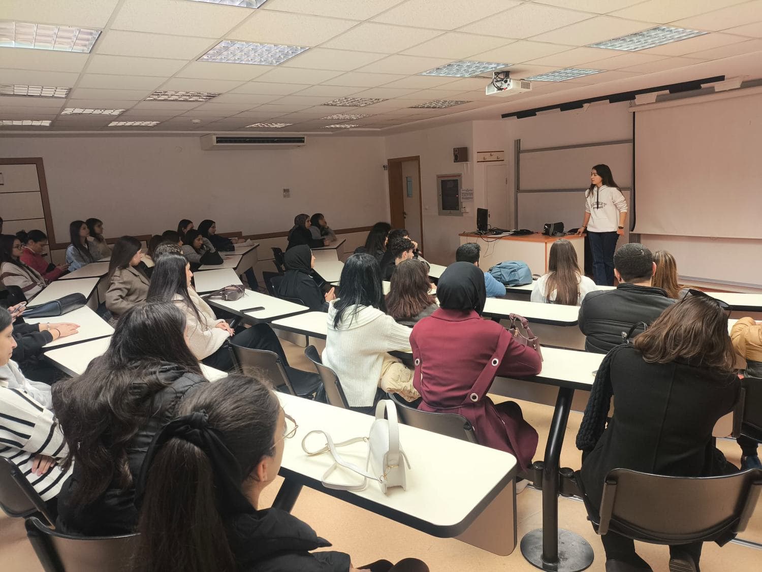 Üniversitede düzenlenen sunumu dinleyen öğrenciler